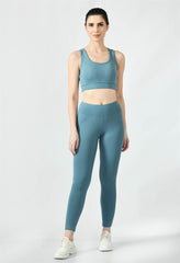 Waylene's airforce blue women's track suit with a sleek tank top and matching leggings, model standing straight facing the camera, paired with white sneakers.